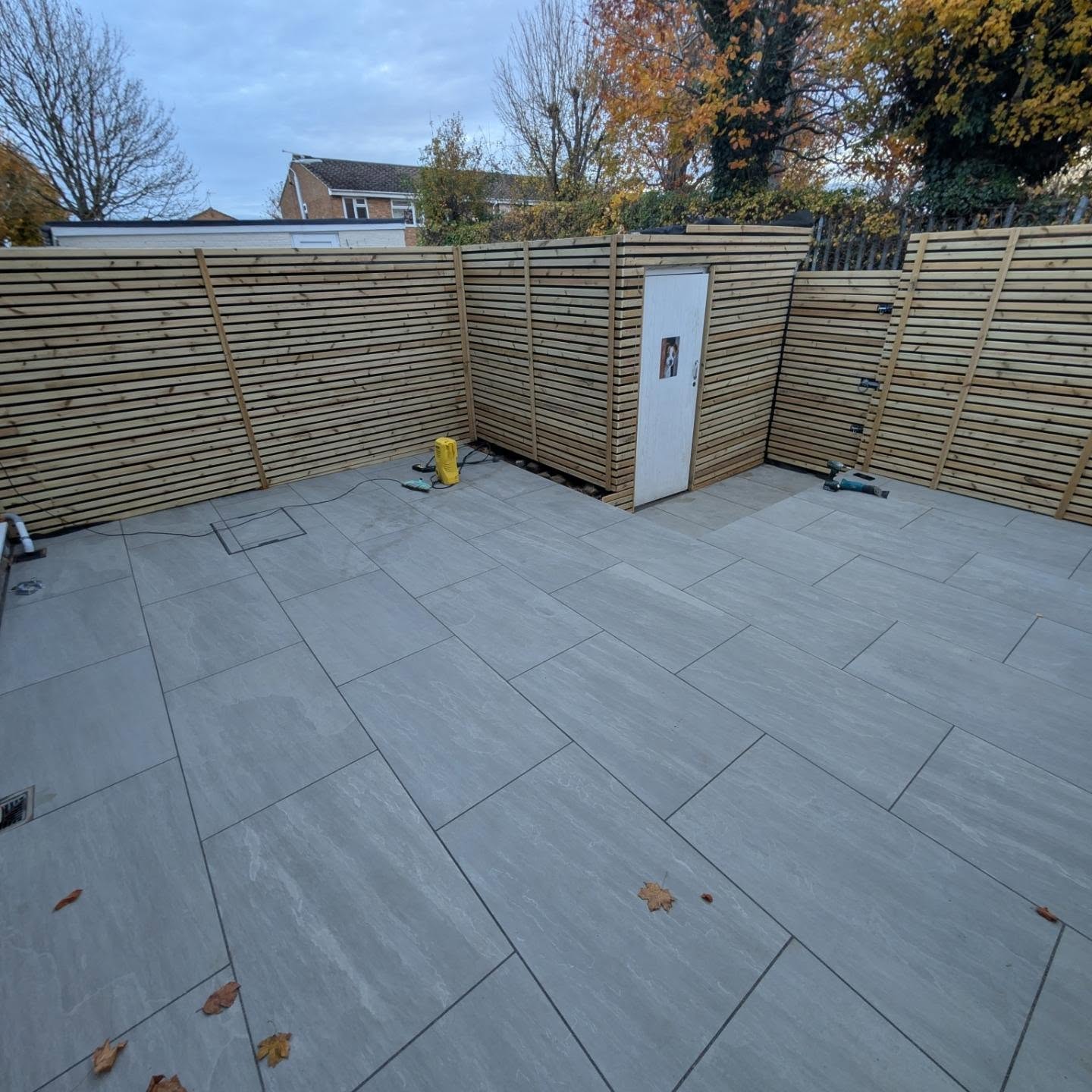 Large porcelain patio surrounded by slatted fencing
