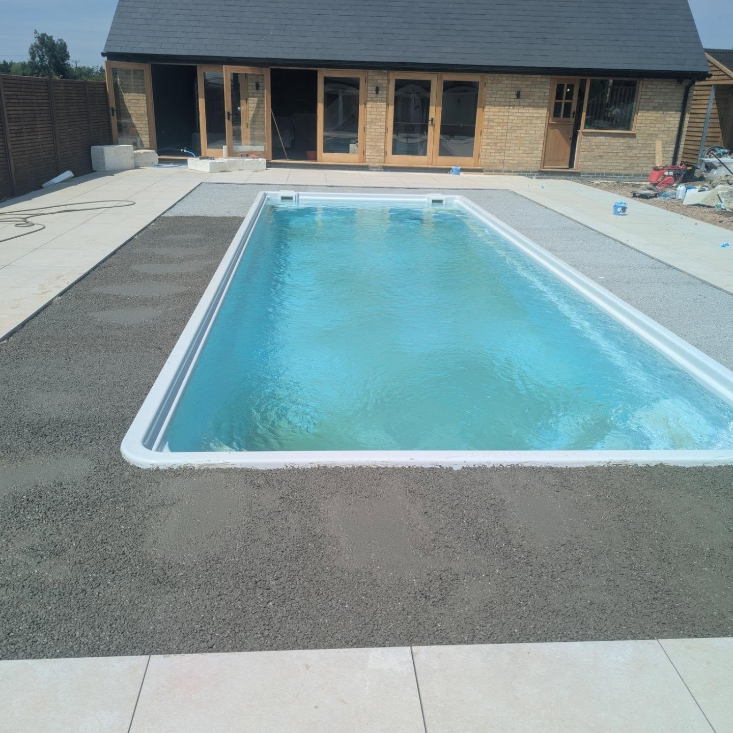 Swimming pool and porcelain surround after completion by Ground Up Landscaping
